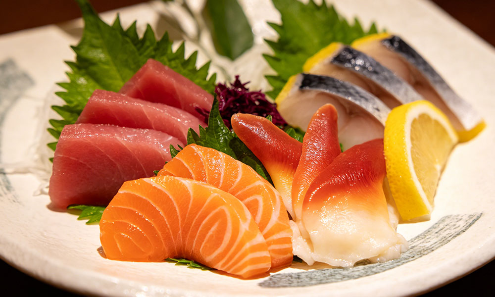 Assorted nigiri sushi with tuna, salmon, surf clam, and lemon garnish
