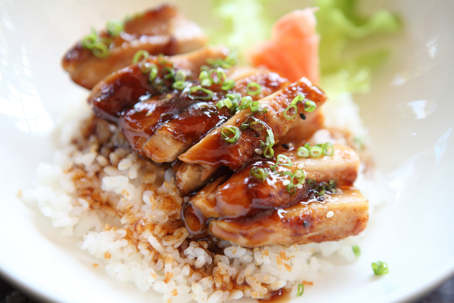 Glazed teriyaki chicken donburi rice bowl topped with chopped green onions at Maya, an Asian Fusion Restaurant in Pittsburgh