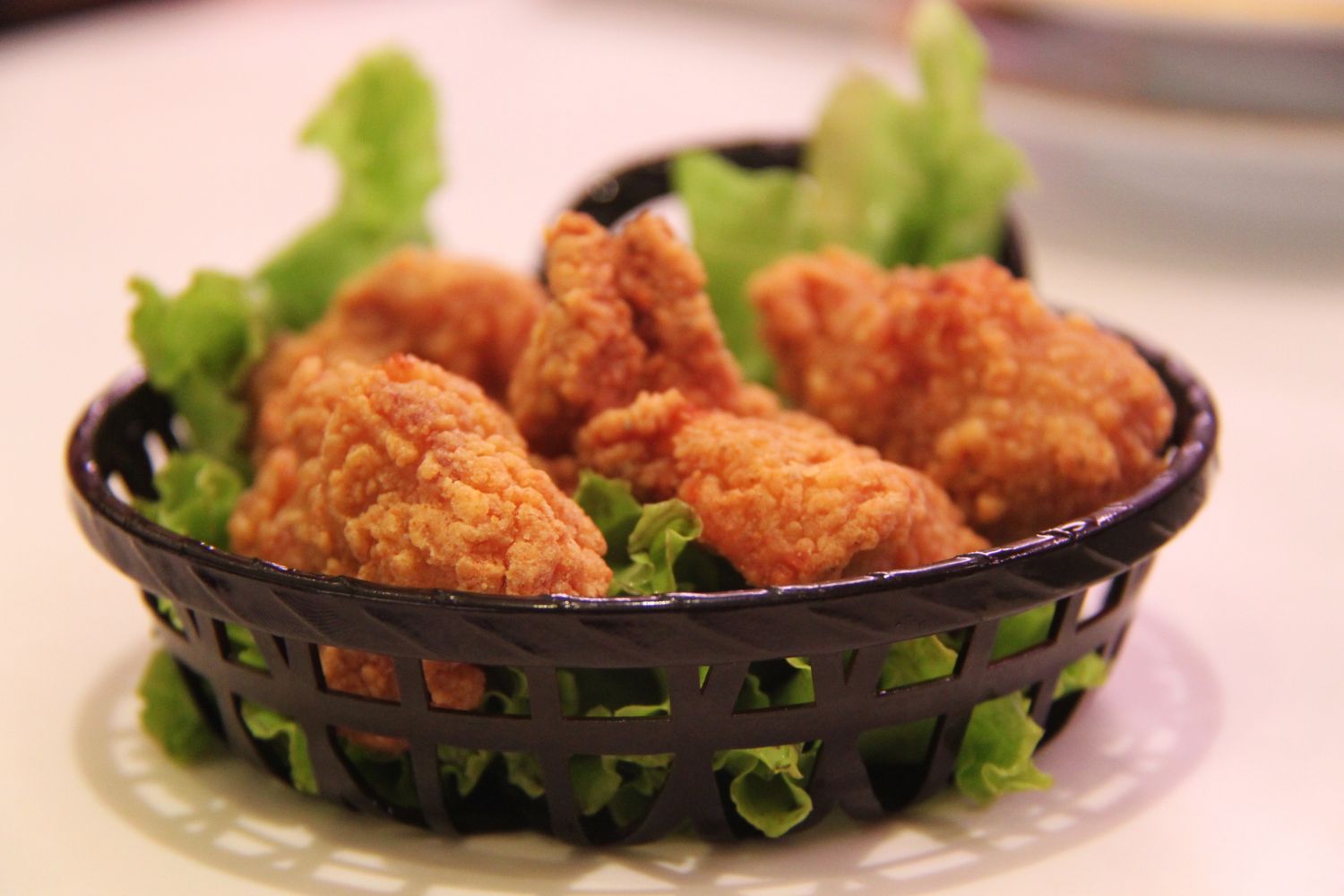 Breaded fried chicken bites in a black basket at MBL & Q Burger, Fried Chicken Shop in Rowland Heights