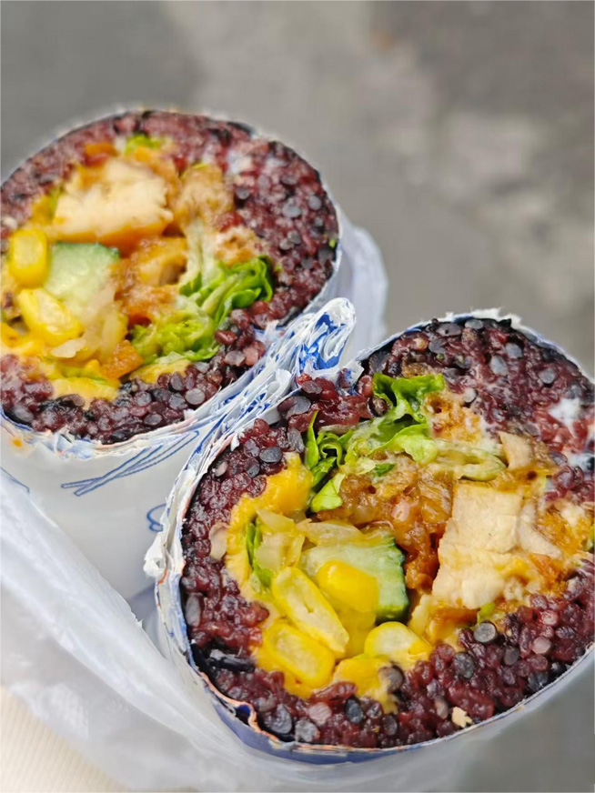 Purple sticky rice wrap packed with chicken, corn, cucumber and fresh lettuce fillings at Meet Again Cafe, a Cafe in Scotch Plains