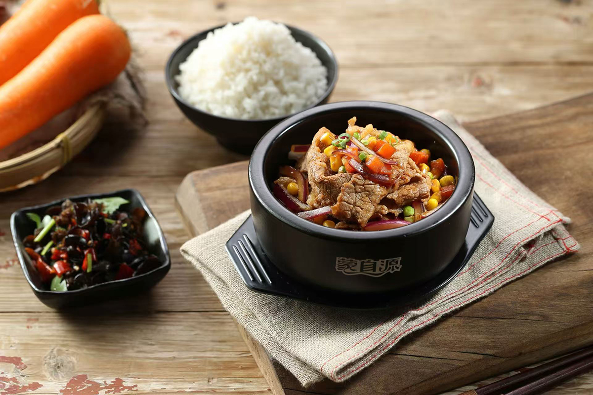 A stone pot with beef and vegetables, served with a bowl of rice and a side dish at Meet Rice Noodle，a Authentic Rice Noodle Restaurant in Fremont
