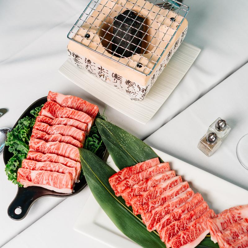Premium beef slices with a small grill setup at Megu French Japanese Cuisine in Fort Worth
