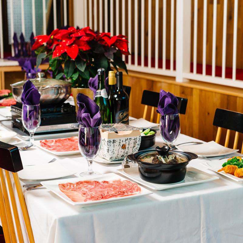 Elaborate dining table with beef, hot pot and wines at Megu French Japanese Cuisine in Fort Worth