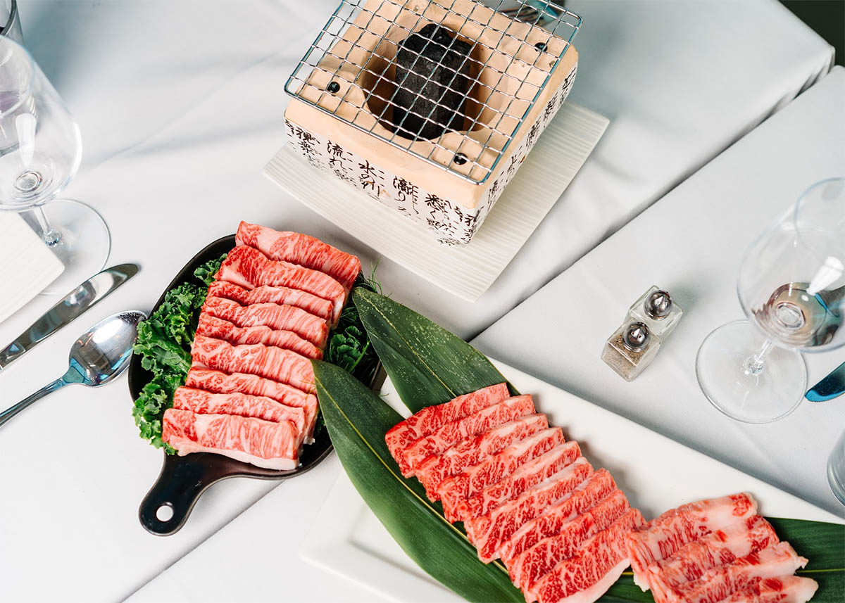 Platters of marbled premium beef with a small grill at Megu French Japanese Cuisine in Fort Worth