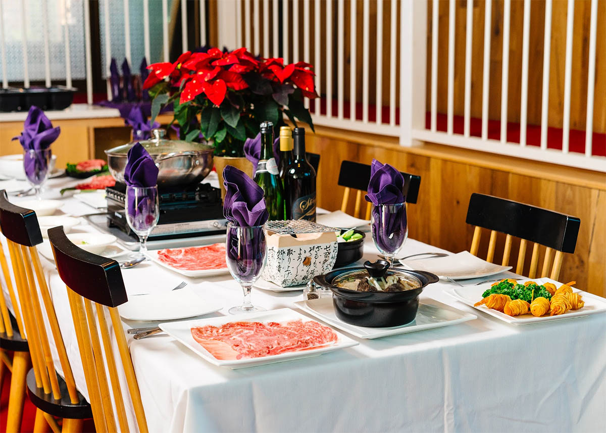 Elaborate dining table with beef, hot pot and wines at Megu French Japanese Cuisine in Fort Worth