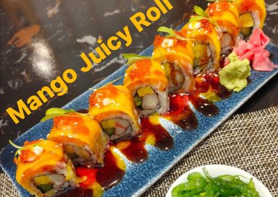 Mango-topped sushi roll with tobiko, multi-colored sauce and pickled ginger garnish at Mex Sushi Taco, a Asian restaurant in Place maspeth
