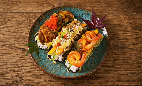 Three handcrafted sushi tacos with shrimp, beef, roe and fresh veggies on textured blue ceramic plate at Mex Sushi Taco, a Asian restaurant in Place maspeth