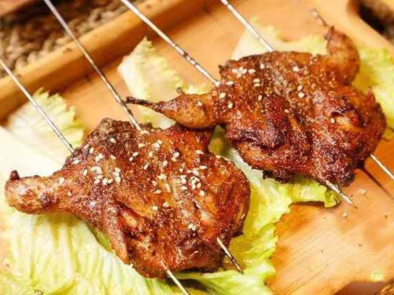 Whole grilled quail with sesame seeds at Pearl BBQ: Chinese Food Truck, a Chinese Restaurant in Elmhurst