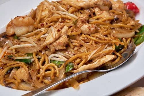 Mint-Bistro-Asian-Fusion-Restaurant-Fried-Noodles-Milford Noodles stir - fried with mixed vegetables, served on a white plate at Mint Bistro,a Asian Fusion Restaurant in Milford