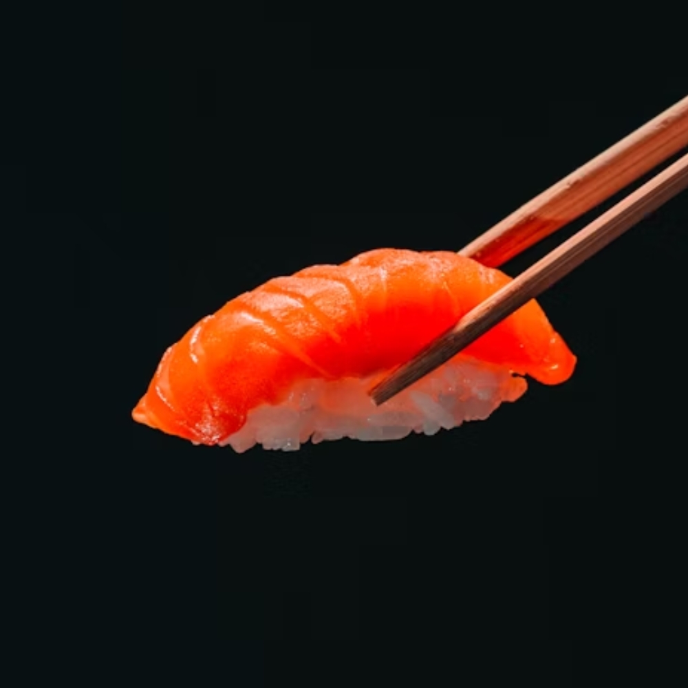 Salmon nigiri sushi held by chopsticks at Mizuki A.Y.C.E Sushi & Hibachi, a Japanese Restaurant in Baytown