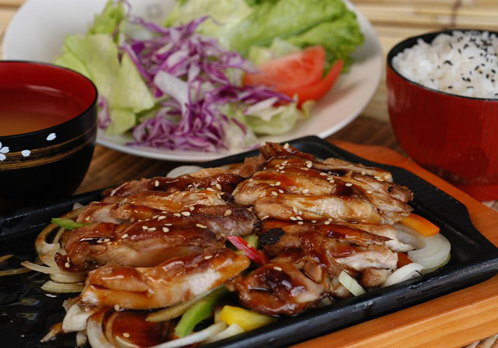 Grilled chicken in teriyaki sauce on hot plate at Mizu, a Japanese Restaurant in Brooklyn