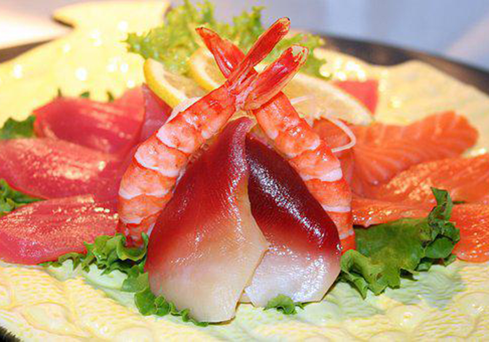 Assorted fresh sashimi with lemon and greens at Mizu, a Japanese Restaurant in Brooklyn