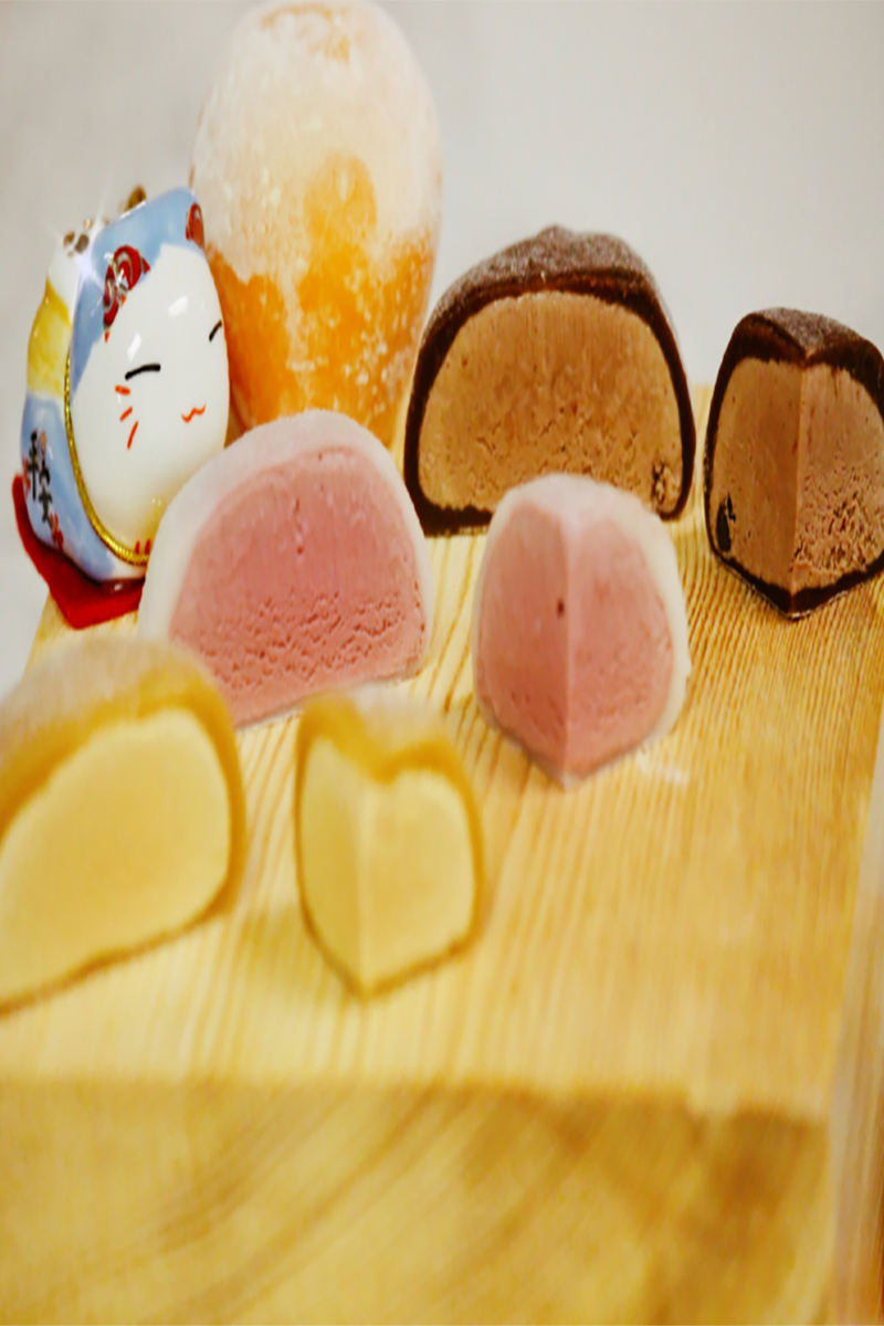Assorted mochi desserts with colorful flavors on a wooden board