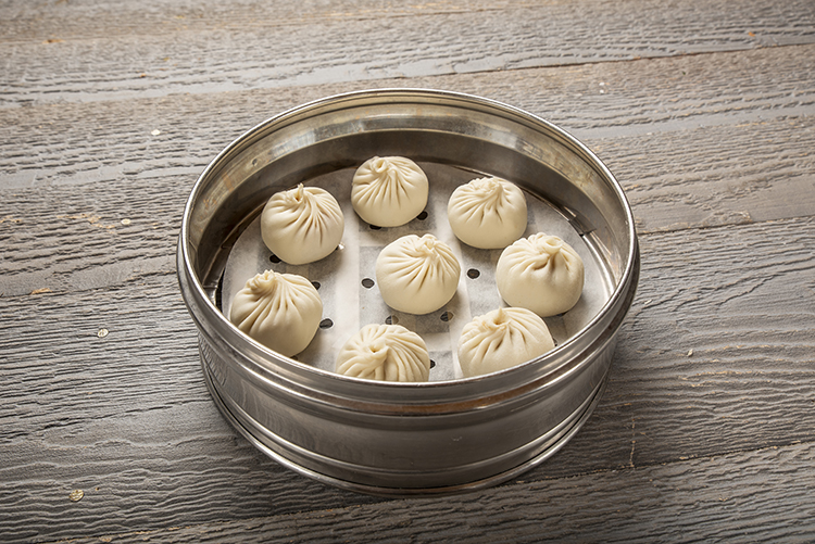 Steamed soup dumplings in a bamboo steamer at Mr.Dragon Noodle House, a Chinese Restaurant in CA Steamed soup dumplings in a bamboo steamer at Mr.Dragon Noodle House, a Chinese Restaurant in CA