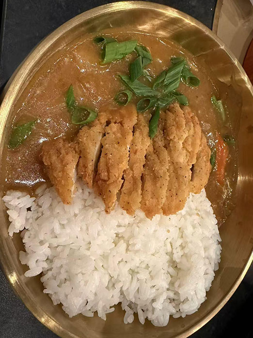 Crispy fried chicken cutlet with curry sauce over steamed rice at Mr.Kimchi Korean Bistro, a Korean Restaurant in Oklahoma City