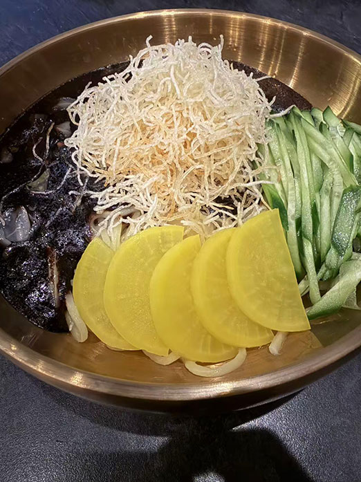 Cold black bean noodles with cucumber and pickled radish at Mr.Kimchi Korean Bistro, a Korean Restaurant in Oklahoma City
