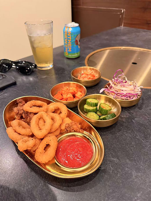 Fried calamari rings and sides with a beer on a table at Mr.Kimchi Korean Bistro, a Korean Restaurant in Oklahoma City
