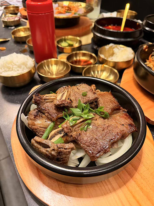 Grilled beef short ribs with onions in a stone bowl at Mr.Kimchi Korean Bistro, a Korean Restaurant in Oklahoma City