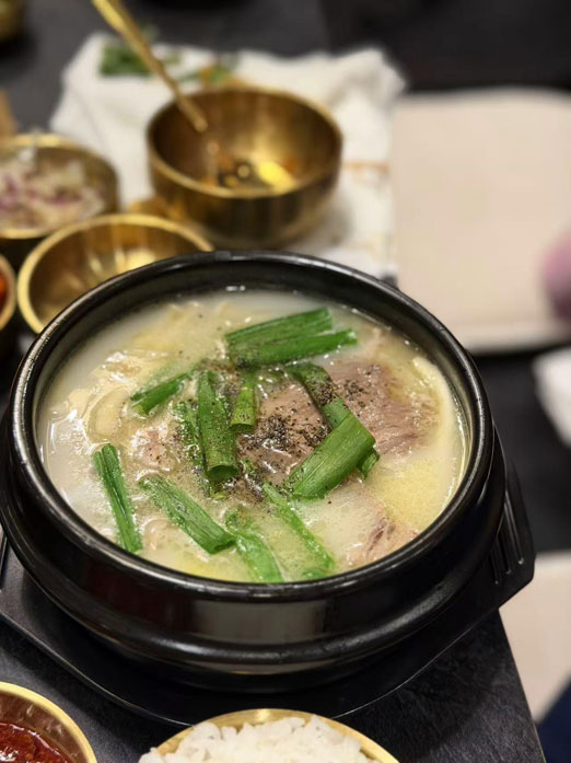 Beef bone soup with green onions and pepper in a black stone bowl at Mr.Kimchi Korean Bistro, a Korean Restaurant in Oklahoma City