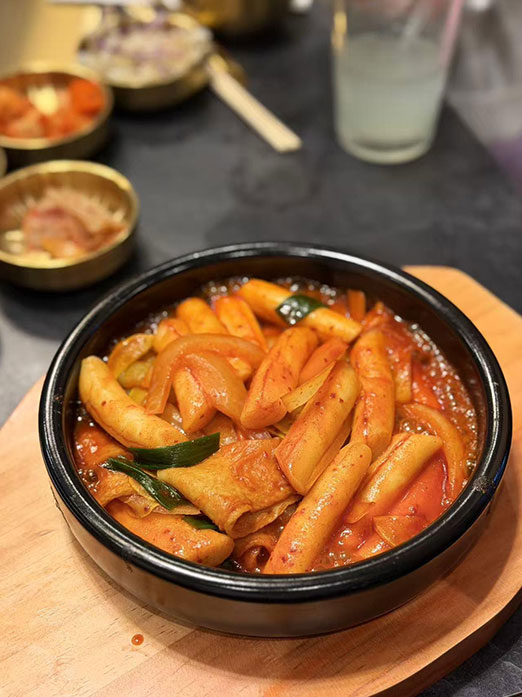 Spicy tteokbokki rice cakes with fish cakes and onions in red sauce at Mr.Kimchi Korean Bistro, a Korean Restaurant in Oklahoma City