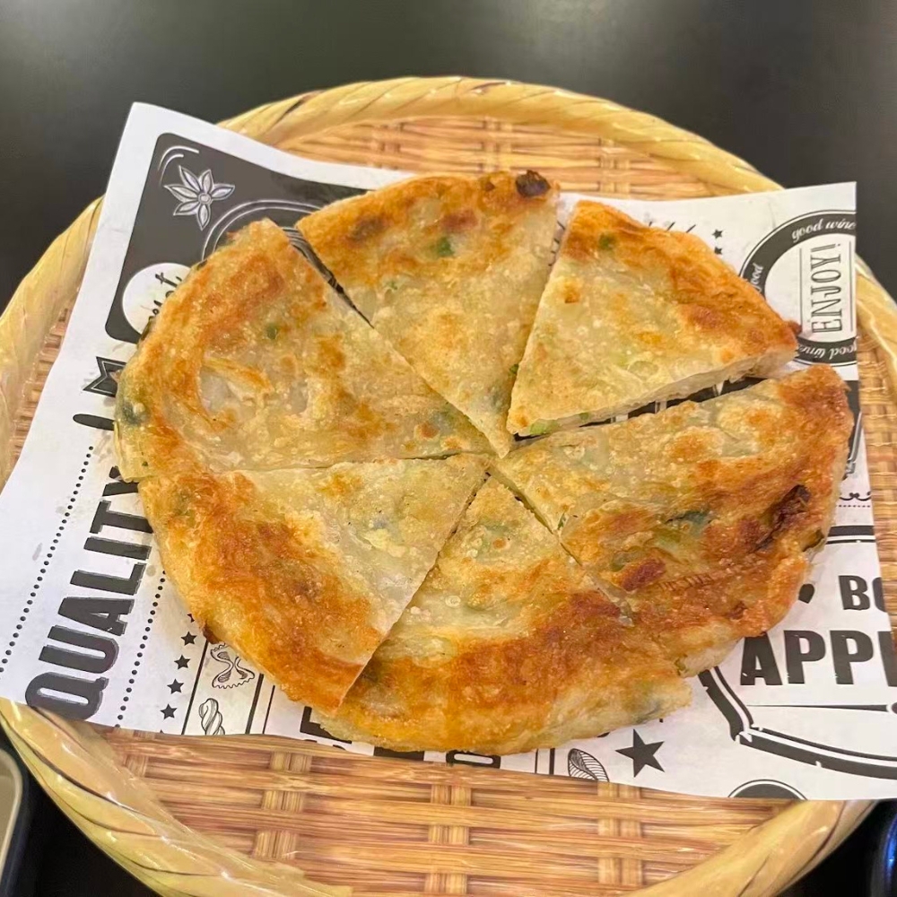 Mr-Zhang-Kitchen-Asian-Restaurant-Scallion-Pancake-River-Edge Crispy scallion pancake, cut into slices, served on a bamboo tray at Mr Zhang Kitchen, a Asian restaurant in River Edge