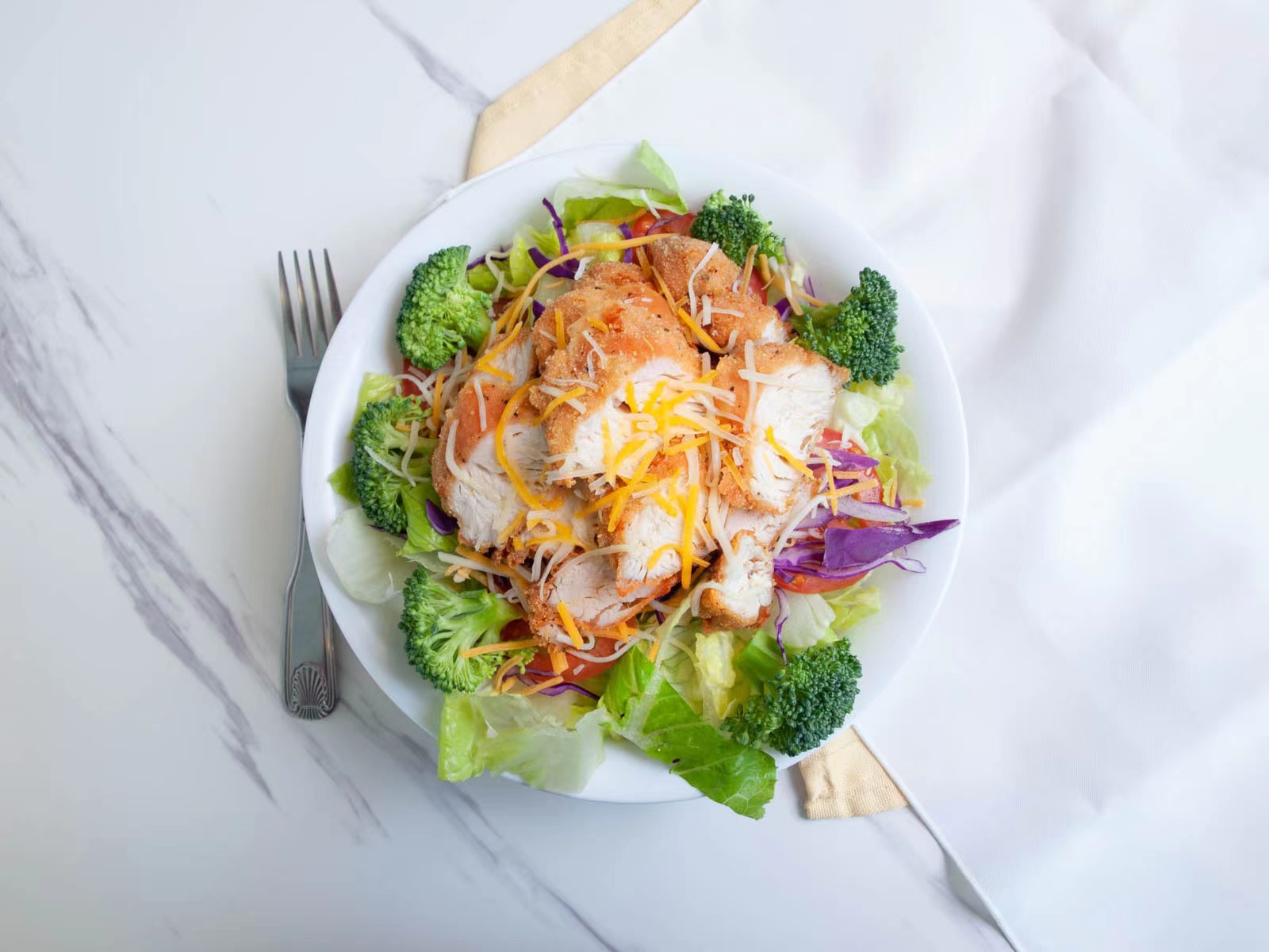Fresh salad topped with fried chicken strips at M TOWN WING, a Chicken Wings Restaurant in Middletown