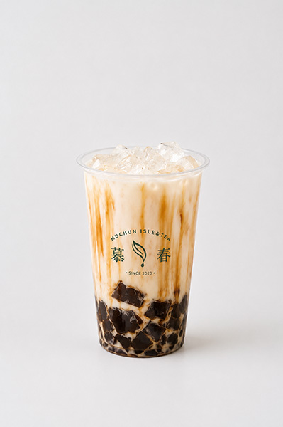 Brown sugar boba milk tea with syrup drizzle, grass jelly and clear ice in Muchun branded plastic cup at Muchun Isle & Tea, a Bubble Tea Shop in Bayside.
