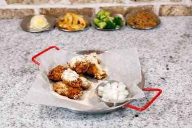 Fried chicken with cheese powder and pickled radish in a metal tray