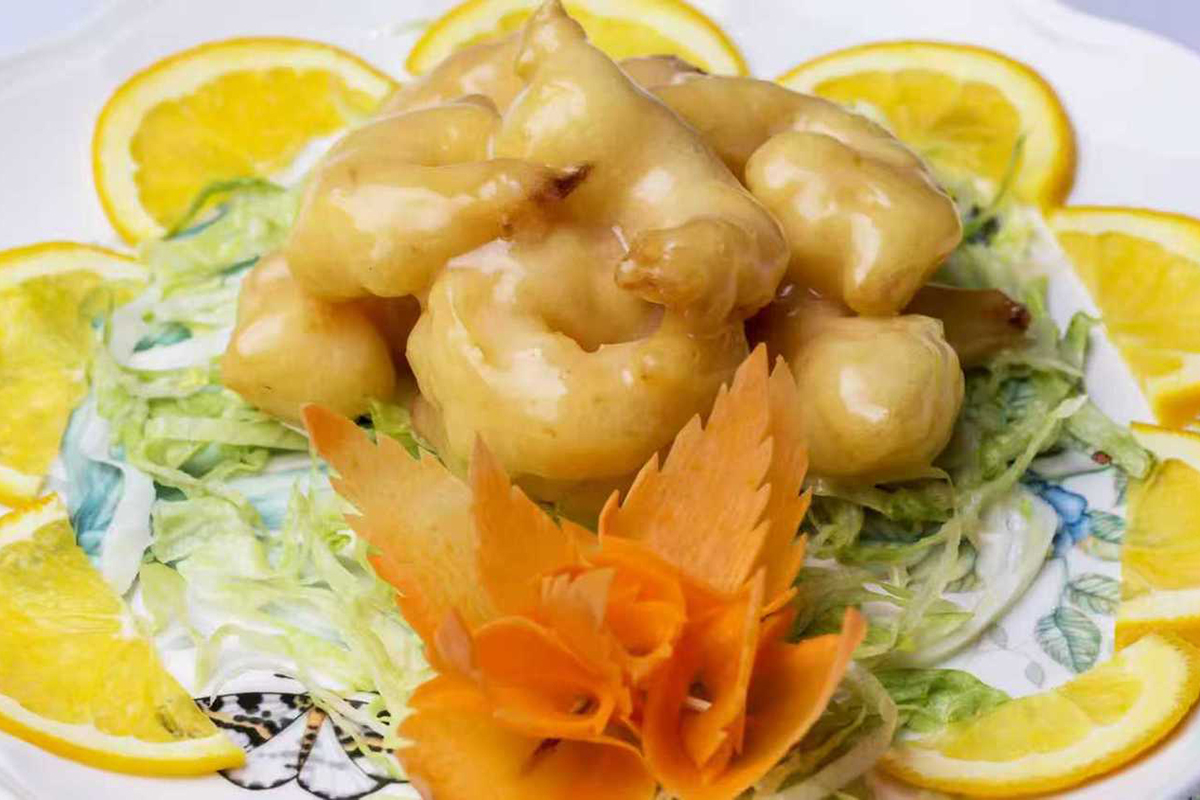 Crispy glazed shrimp garnished with orange slices, shredded lettuce, and a carved carrot flower at New China Two，a Chinese Restaurant in Redding