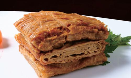 Stacked braised tofu skin slices on a plate at New Shanghai No. 1, a Chinese restaurant in San Gabriel
