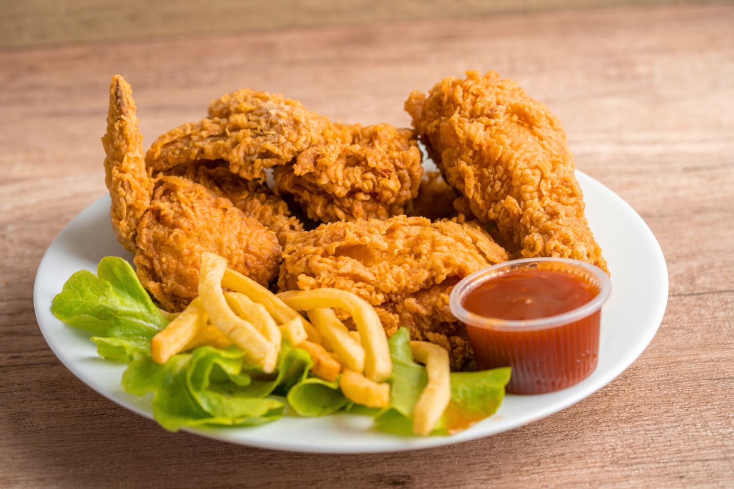 Fried chicken platter with wings, fries, and dipping sauce on a plate at NEW YORK BUFFALO WINGS, a American restaurant in Forest Park