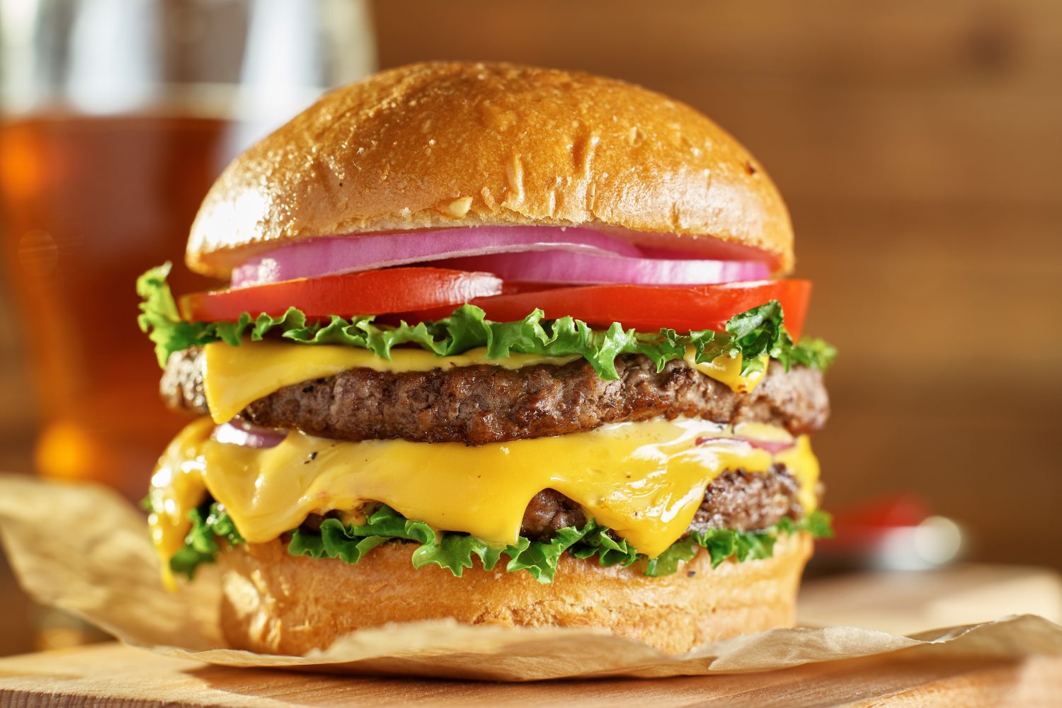 Double cheeseburger with melted cheese, lettuce, and tomato on a bun at NEW YORK BUFFALO WINGS, a American restaurant in Forest Park