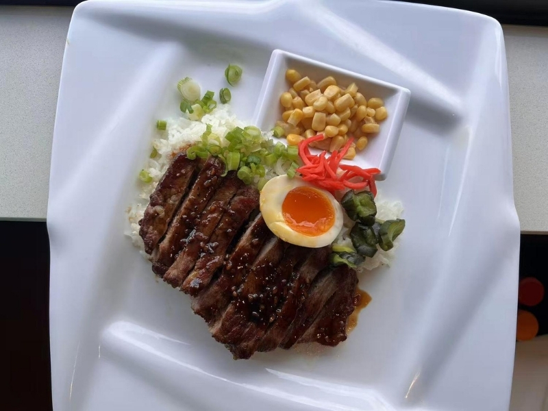 Rice bowl with teriyaki steak, egg, corn, and green onions at Ninja Ramen, a Japanese Restaurant in Englewood