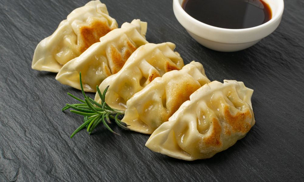 Pan-fried pork gyoza with soy sauce and rosemary garnish at Noodle House, a Japanese Sushi Restaurant in Flemington