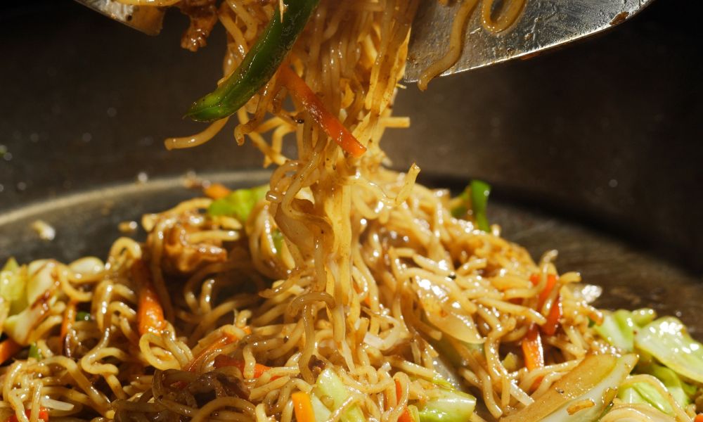 Stir-fried noodles with vegetables being lifted from a wok at Noodle House, a Japanese Sushi Restaurant in Flemington