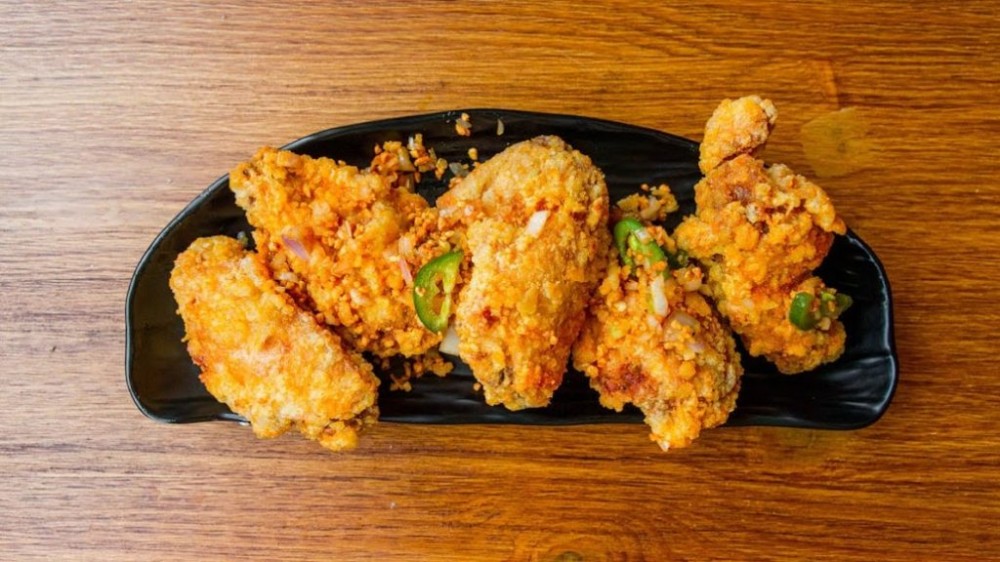 Crispy fried chicken wings with green pepper garnish at Noodle Man , a Noodle shop in Virginia Beach