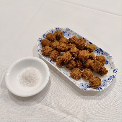 Deep‑fried meatballs served with a dish of fine salt powder.