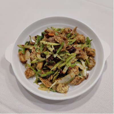 Spicy stir‑fried crispy pork with green vegetables and dried chili.