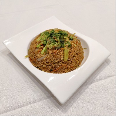 Vegetable fried rice topped with fresh broccoli florets.