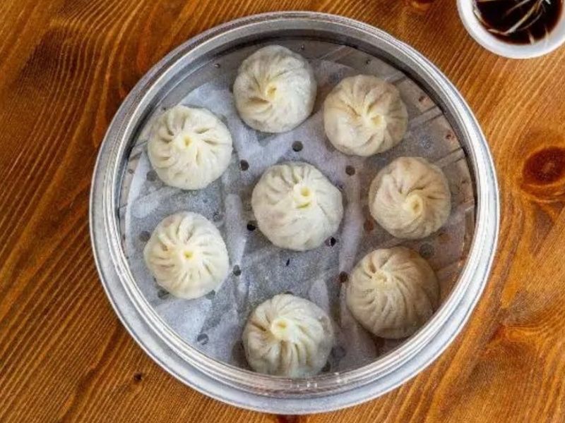 Steamed soup dumplings served with dipping sauce at Northern Cafe, a Chinese Restaurant in CA