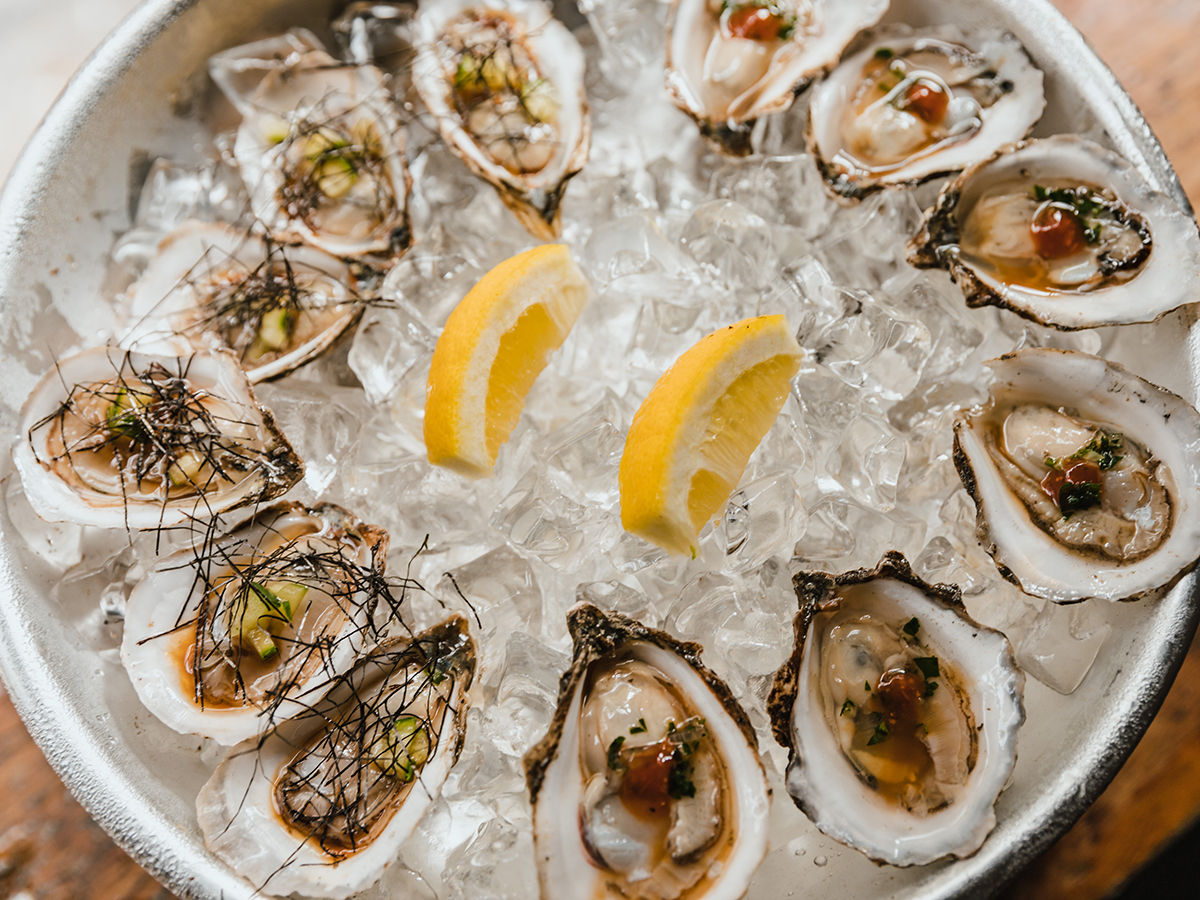 Fresh oysters on ice with lemon wedges and garnishes at Ocean 7 Boiling Seafood & Bar Restaurant in Olympia
