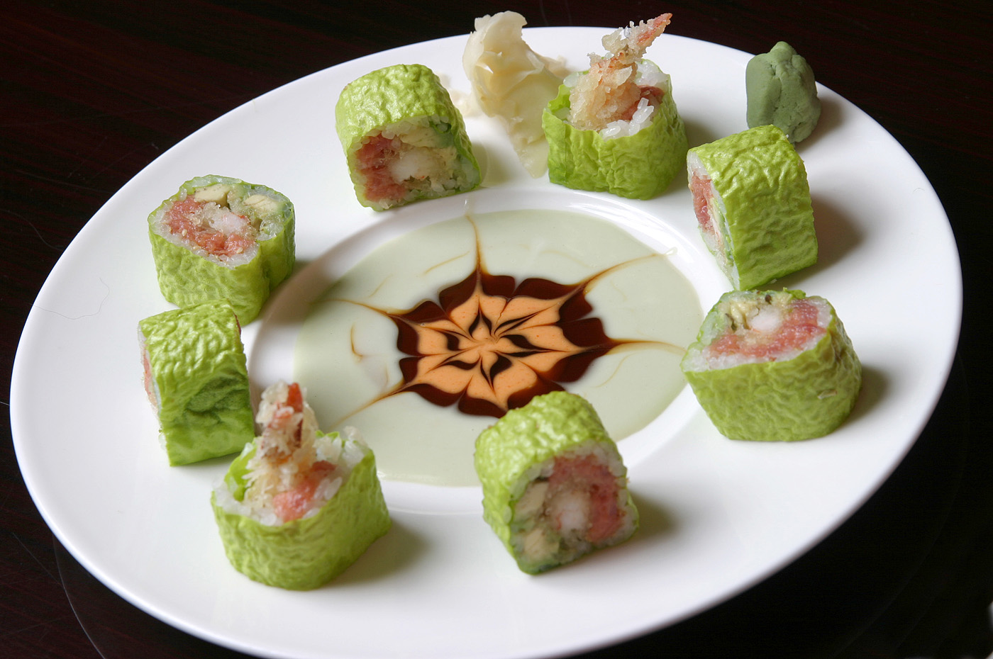 Green wrapper sushi rolls with shrimp and artistic sauce drizzle at Ocha Asian-Japanese Cuisine，a Asian Restaurant in Caldwell