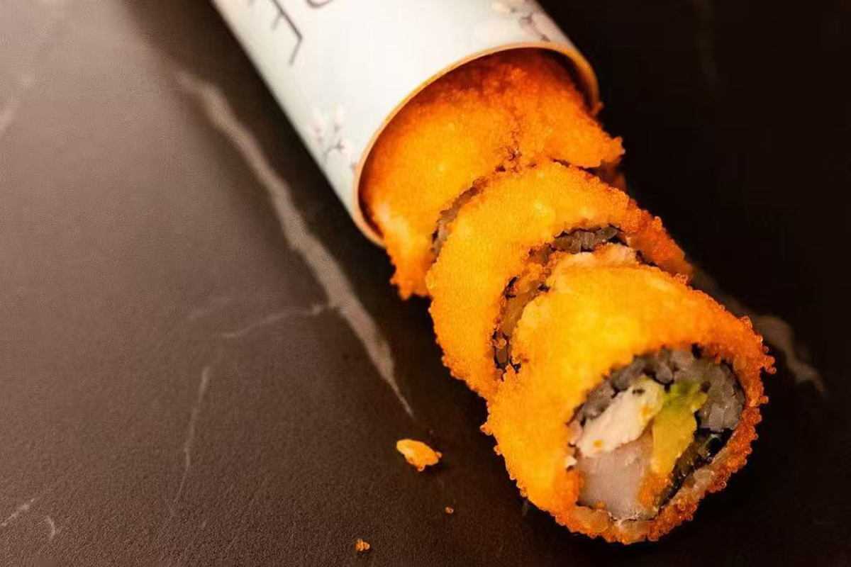 Fresh sushi roll wrapped in crispy masago, filled with crab, avocado, and cheese at Oishii Express, a Japanese Restaurant in Oklahoma City
