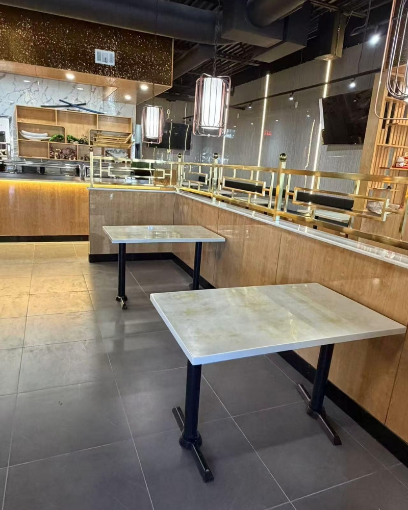Clean, modern dining area with tables and gold accents at Oishii Sushi House, a Japanese Restaurant in Dacula.
