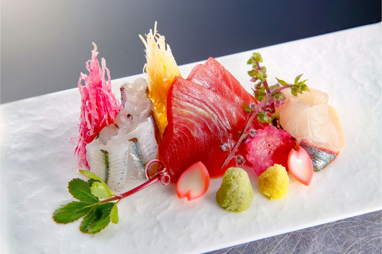 Artfully arranged premium mixed sashimi platter with garnishes and wasabi