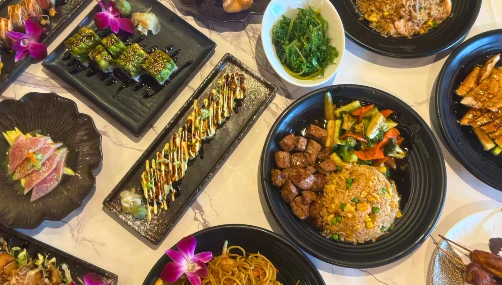 Okayama-Sushi-&-Hibachi-Japanese-Restaurant-Assorted-Dishes-Orlando A variety of Japanese dishes including sushi, noodles, and grilled meats at Okayama Sushi & Hibachi, a Japanese Restaurant in Orlando