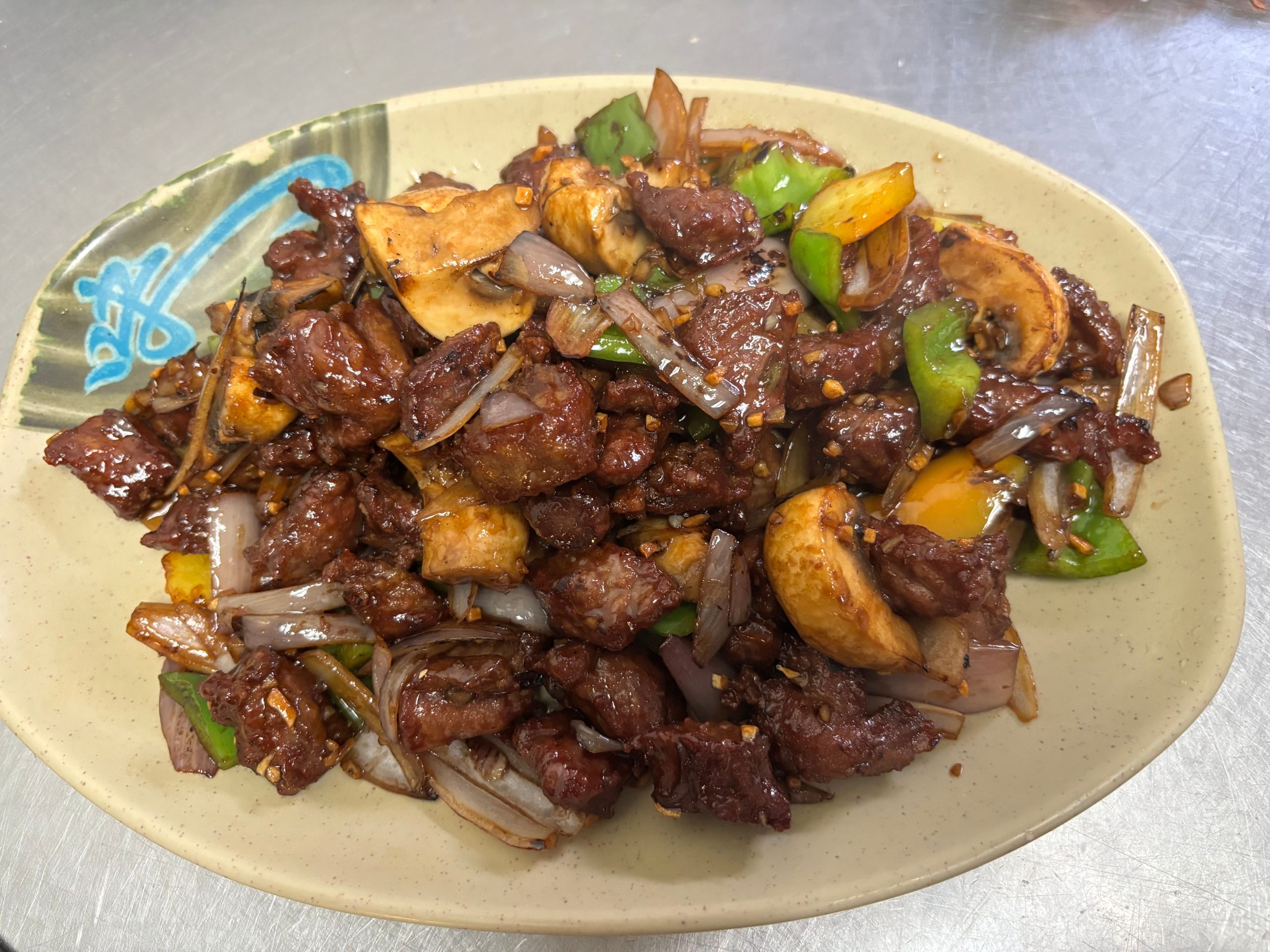 Stir-fried lamb chunks with green onions, bell peppers and yellow onions at The Wok, an Asian Fusion Restaurant in Rochester