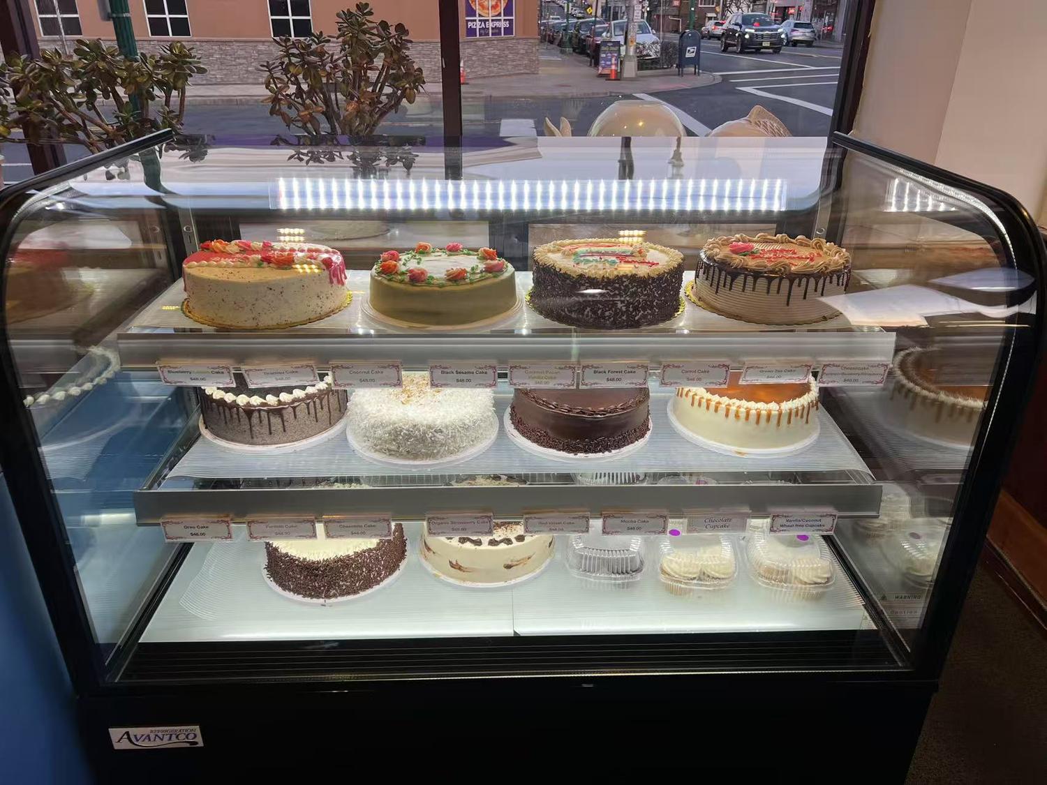 Display Case Featuring a Variety of Cakes and Pastries in a Bakery or Cafe Setting