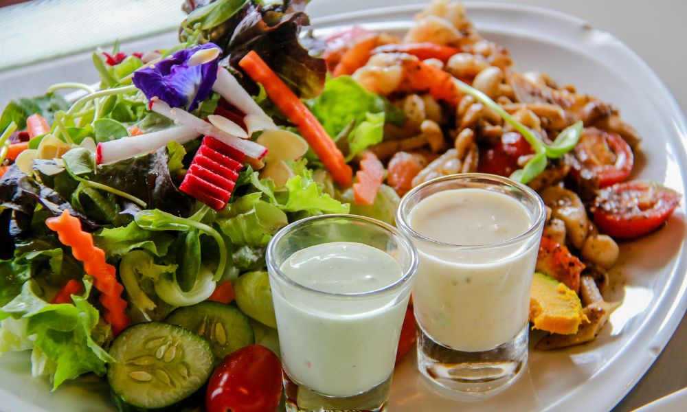 White platter of garden mixed salad, shrimp and two small glass pots of creamy house dressing at Zen Bowl, a Healthy Poke Restaurant in Imperial