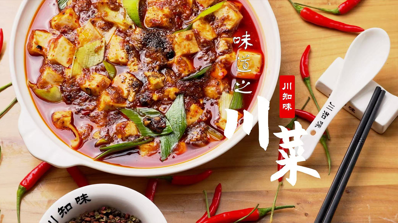 Orient-Express-Chinese-Restaurant-Mapo-Tofu-Baltimore Classic Mapo Tofu in a white bowl, featuring soft tofu cubes in a spicy, savory sauce with green onions, set beside chopsticks and red chilies.